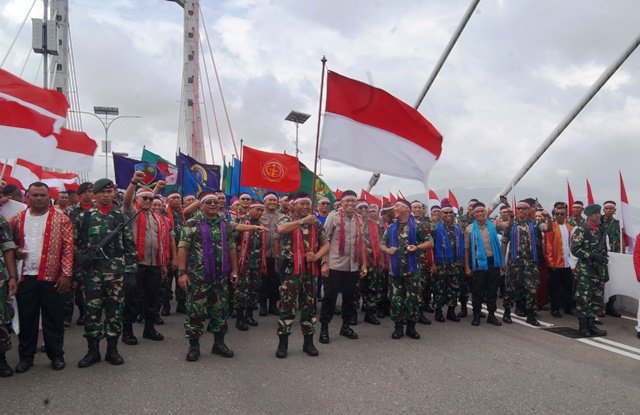Pangdam Pattimura membawa bendera Merah Putih yang diserahkan Kapolda Maluku di Jembatan Merah Putih Ambon.