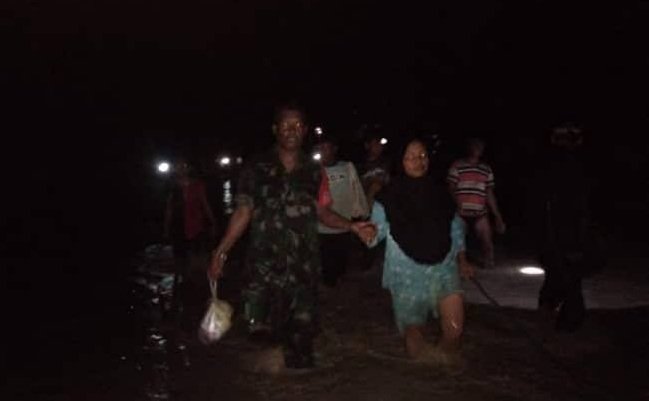 Babinsa Koramil 1502-05/ Wahai, Serda Ampi Latuola dan Serda Babudin tampak Tengah Mengevakuasi Warga di Kabupaten Maluku tengah, Maluku yang Terkena Banjir, pada Sabtu, (23/02/2019).