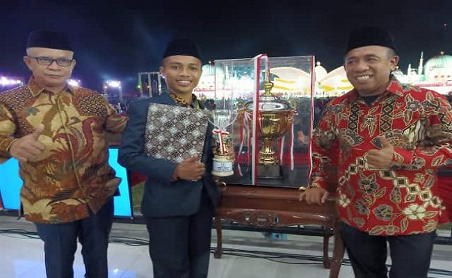 Muhammad Iqbal yang meraih juara pertama Musabaqah Makalah Quran (MMQ) Tingkat Provinsi Maluku ke 28, bersama Bupati Buru Ramly Ibrahim Umasugi SPI MM usai menerima hadiah Umrah dari Pemkab Buru, Jumat malam lalu (21/6/2019) (FOTO:BERITABETA.COM)