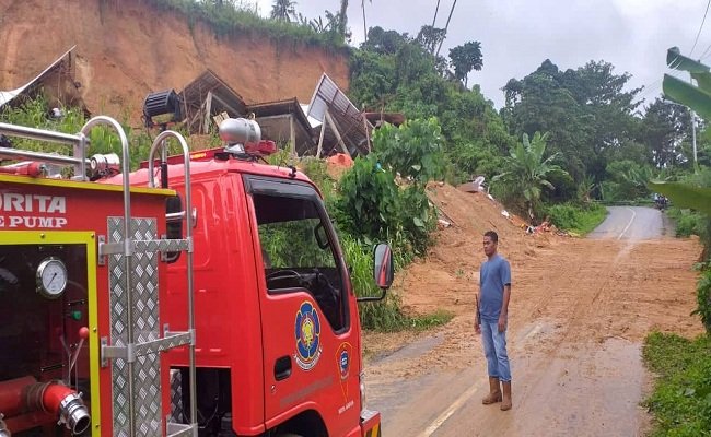 Pembersihan material longsor yang menutupi ruas jalan menuju dusun Taeno dengan menggunakan dua unit mobil damkar milik Pemkot Ambon  