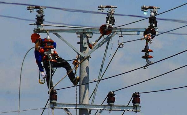 Petugas PLN tengah memasang jaringan listrik 