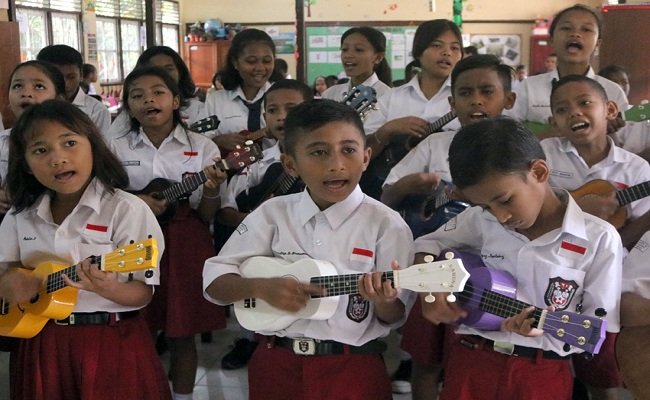 Sejumlah siswa-siswi  SD Inpres 42 Ambon, Desa Amahusu, Ambon, Maluku memainkan alat musik ukulele saat peluncuran program ‘Ukulele Masuk Sekolah’ di SD,  Selasa (23/7/2019).