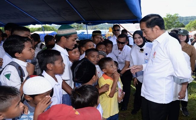 Presiden Jokowi mengajak biacara seorang anak di lokasi pengungsian usai membagikan sejumlah buku kepada puluhan anak, di lokasi pengungsian Kampus Universitas Darussalam, Tulehu, Kabupaten Maluku Tengah, Selasa (29/10/2019). (FOTO : HUMASMALUKU)