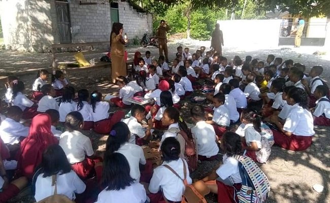 Sejumlah murid SDN Waeura, Kecamatan Waplau, Kabupeten Buru,  terpaksa mengikuti proses belajar mengajar di bawah pohon, setelah bangunan sekolah dipalang oleh pemilik lahan. Tampak beberapa guru sedang mengajar di bawah pohon, Selasa (21/1/2020).  
