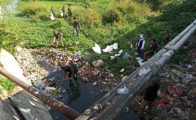 Personil GPS dan TNI bersama petugas dari Dinas Lingkungan Hidup Provinsi Maluku serta para Lurah di Kota Ambon, sedang membersihkan tumpukan sampah yang dibuang di sungai di bawah Jembatan Waitomu, Kelurahan Uritetu, Jumat (14/02/2020) (FOTO: BERITABETA.COM)