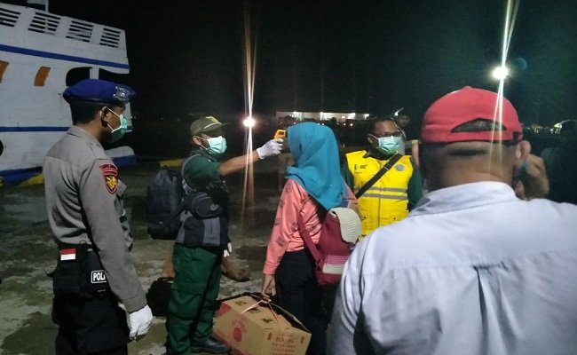 Seorang penumpang KM Fajar Baru 08 yang baru tiba dari Kota Sorong, Provinsi Papua, menjalani tes suhu tubuh yang dilakukan oleh petugas dari Balai Karantina Kabupaten SBT, di Pelabuhan Bula, Desa Sesar, Selasa malam (17/03/2020) (FOTO: Humas Polres SBT)  