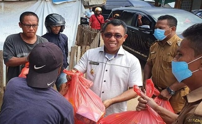 Bupati Buru Ramli Umasugi membagikan paket sembako kepada warga di Kota Namlea, Selasa (14/4/2020)