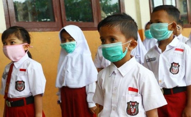 Siswa sekolah dasar negeri 002 Ranai melakukan aktivitas belajar menggunakan masker di Kabupaten Natuna, Kepulauan Riau, Indonesia, Selasa (4/2/2020). 
