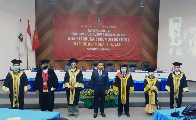 Hasrul Buamona di ruang Audiotorium Program Doktor Hukum UII Yogyakarta, saat menjalani Ujian Terbuka Promosi Doktor Hukum Kesehatan dengan desertasinya berjudul ‘Politik Hukum Pasal 21 UU Nomor 44 Tahun 2009 Tentang Rumah Dalam Perspektif Pasal 34 ayat (3) UUD 1945’, Jumat (24/7/2020)