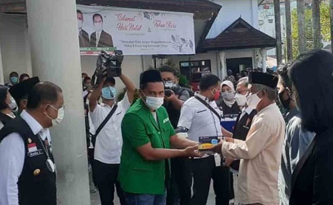 Ketua Gugus Tugas Covid-19 GP Ansor, Masury Maswatu saat menyerahkan bantuan masker kepada perwakilan rumah-rumah ibadah di Kota Ambon yang dipusatkan di halaman parkir Balai Kota Ambon, Rabu (23/12/2020) (FOTO: Istimewa)