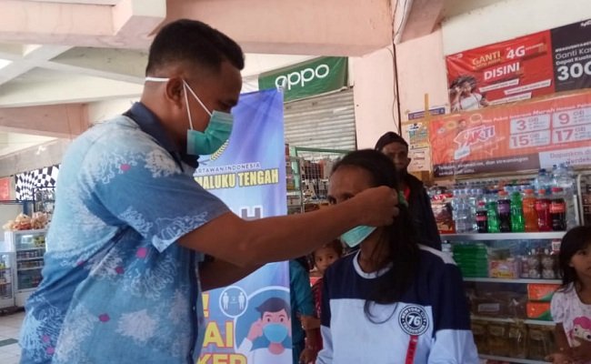 Salah satu anggota PWI Maluku Tengah memasang masker kepada seorang pedagang di Pasar Tradisional Binaiya, Kota Masohi, Rabu (2/12/2020)