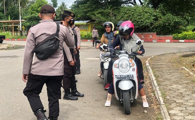 Anggota Polres SBT melakukan Giat Pembagian Masker dan Mengingatkan masyarakat untuk pencegahan penyebaran Covid-19 di Kota Bula