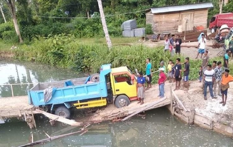 Sebuah truk dengan muatan sarat jatuh ke kali, setelah melintas di Jembatan Darurat Kali Wai Arua, Negeri Danama, Kecamatan Tutuk Tolu,  Kabupaten Seram Bagian Timur (SBT), Kamis (4/3/2021) (FOTO : Istimewa)