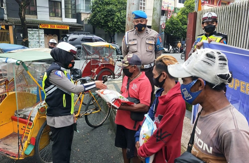 Ditlantas Polda Maluku  melakukan pembagian sembako berupa beras dan masker di sela-sela Ops Patuh di Jalan Imam Bonjol, Kota Ambon, Selasa (21/9/2021)