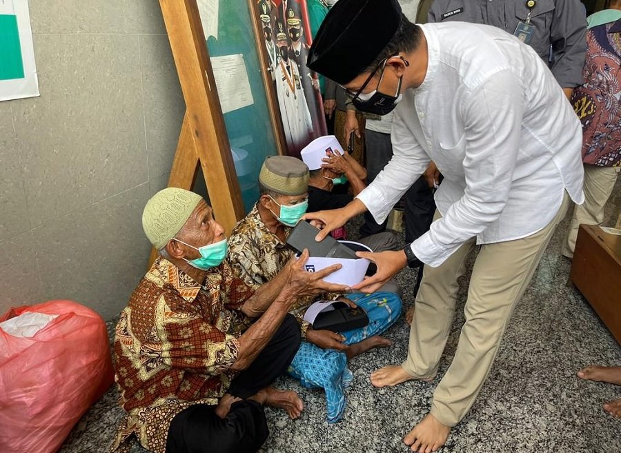 Menteri Pariwisata dan Ekonomi Kreatif Sandiaga Salahuddin Uno berbagi peci kepada jamaah sholat jumat di Masjid Raya Alfatah Ambon