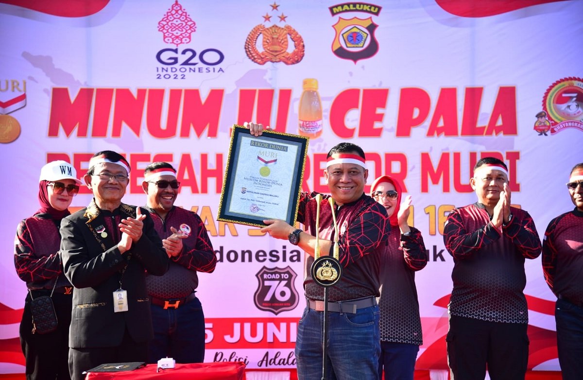 Kapolda Maluku Irjen Pol Lotharia Latif (tengah) memegang piagam Museum Rekor Dunia Indonesia (MURI) untuk pemecahan rekor minum 16.076 botol jus pala, dalam rangka memeriahkan Hari Bhayangkara ke-76 di Kota Ambon, Sabtu (25/6/2022).