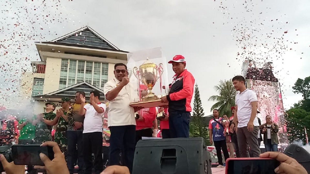 Gubernur Maluku Murad Ismail menyerahkan piala kepada Juara Umum Popmal ke 1V kepada kontingen Kota Ambon  yang diterima Pj. Walikota Ambon saat upacara penutupan Popmal di Lapangan Medeka, Ambon, Minggu (27/11/2022) (foto: istimewa)