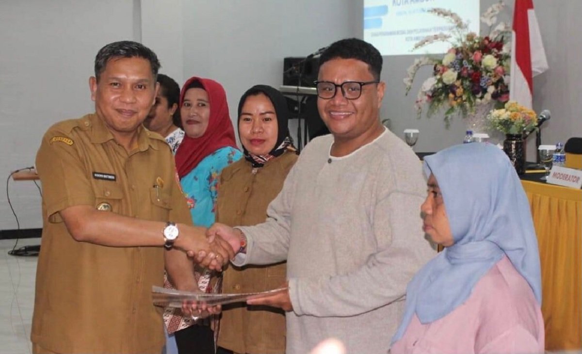 Penjabat  Walikota Ambon Bodewin M. Wattimena saat menyerahkan NIB kepada pelaku usaha UMKM di kegiatan Temu Usaha Membangun Kota Ambon, di Hotel Grand Avira, Senin (16/10/23)