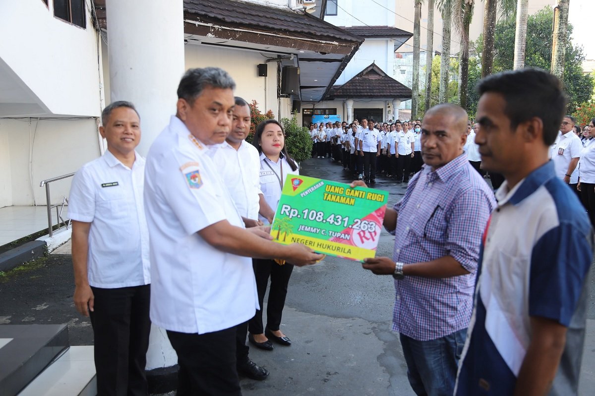 Penjabat Wali Kota Ambon, Dominggus Kaya  menyerahan ganti rugi di sela sela apel pagi pegawai Pemkot Ambon.