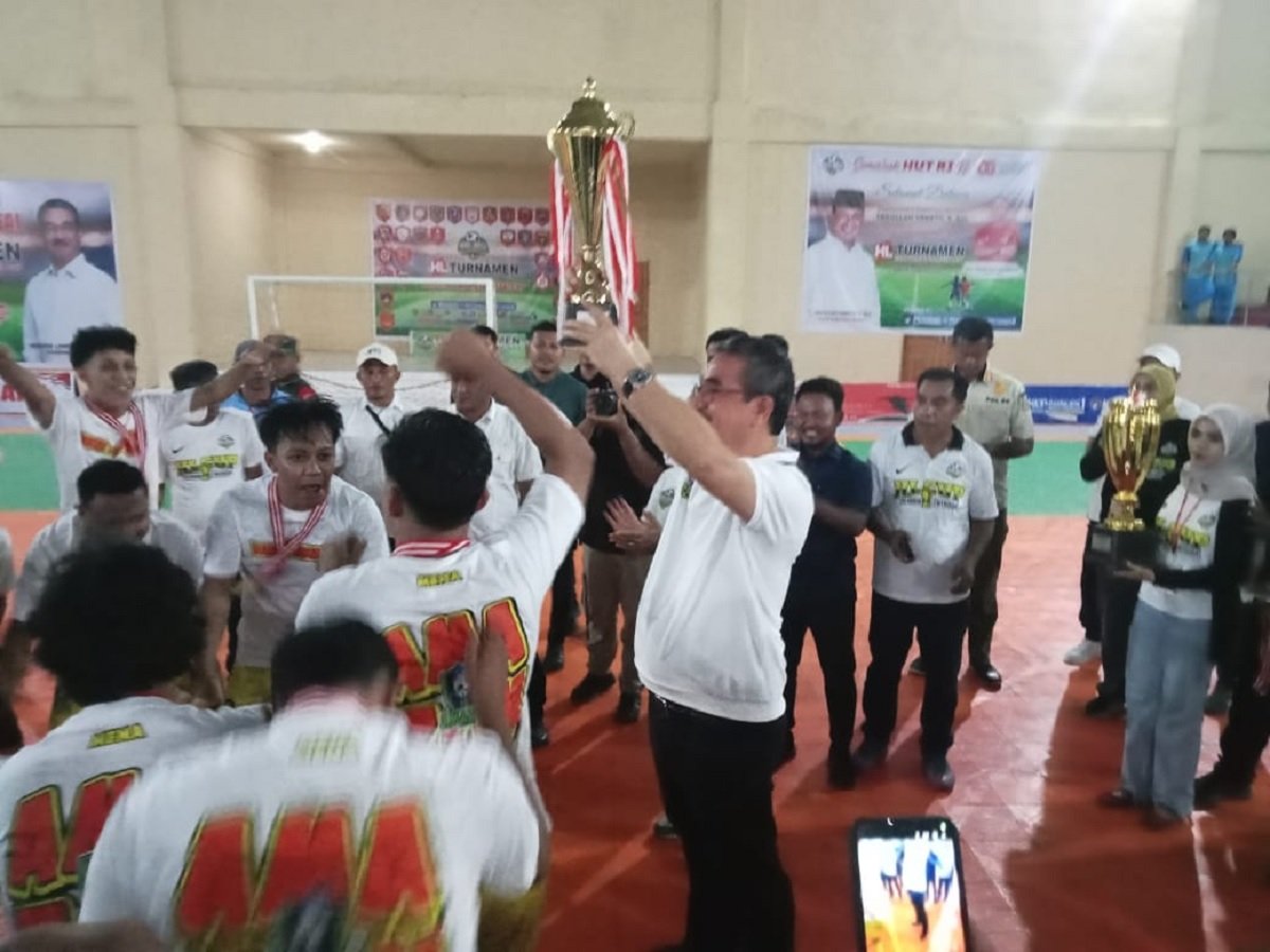 Gubernur Maluku Hendrik Lewerissa mengangkat trofi usai menutup Turnamen Putsal HL Cup di Gor Namlea, Selasa (9/9/2025)