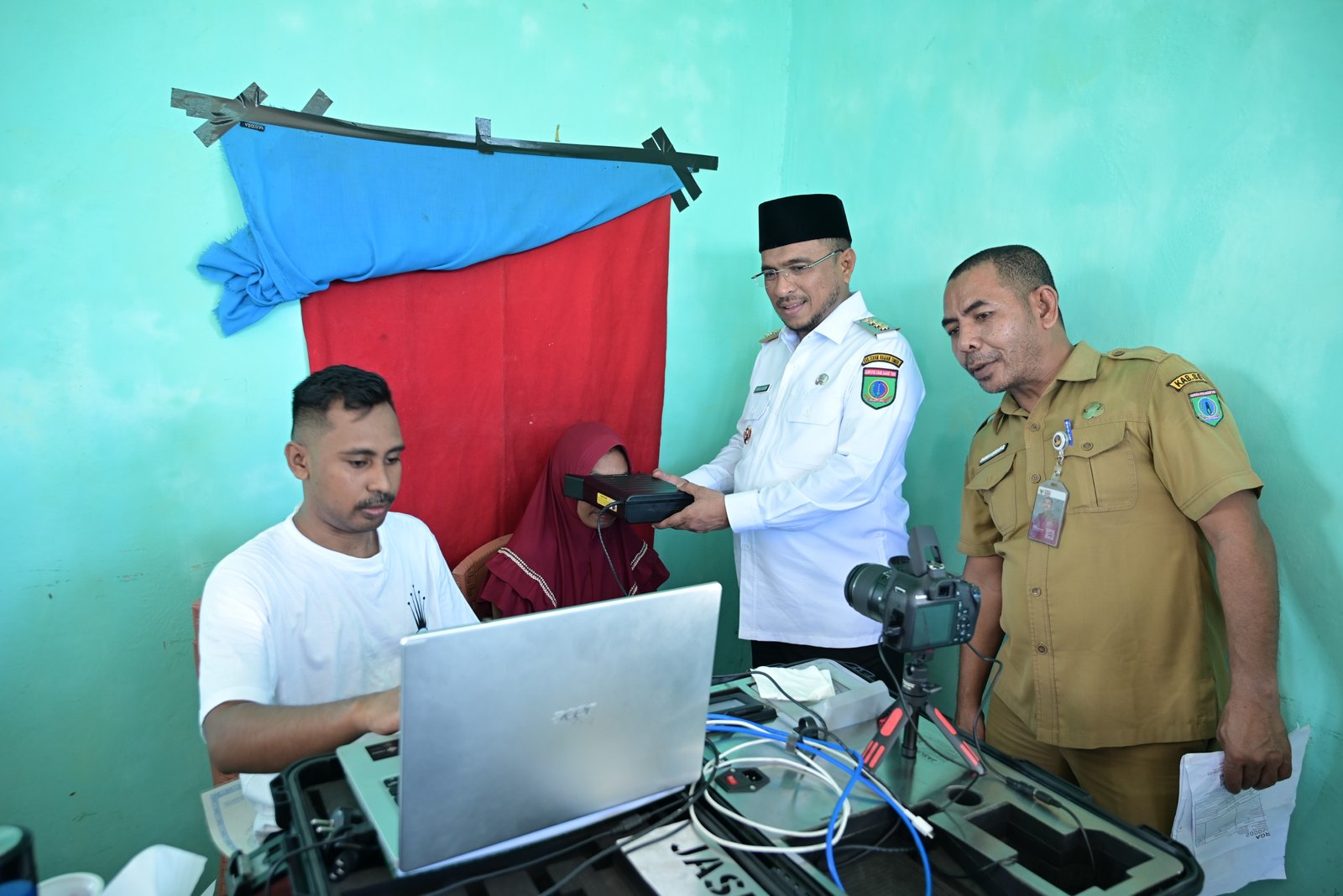 Bupati SBT, Fachri Husni Alkatiri dan Kepala Dinas Dukcapil SBT, Sidik Rumalowak memantau proses perekaman KTP di Desa Batuasa, Kecamatan Werinama. (foto : istimewa)